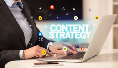 CONTENT STRATEGY yazıtlı, Sosyal medya konseptli dizüstü bilgisayar kullanan serbest çalışan kadın
