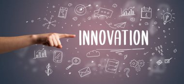 Kesilmiş ellerin yakın çekimi INNOVATION yazıtlarına işaret ediyor, modern iş çözümleri kavramı