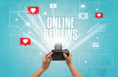 ONLINE REVIEWS yazıtları, sosyal medya kavramı ile fotoğraf çeken bir elin yakın çekimi