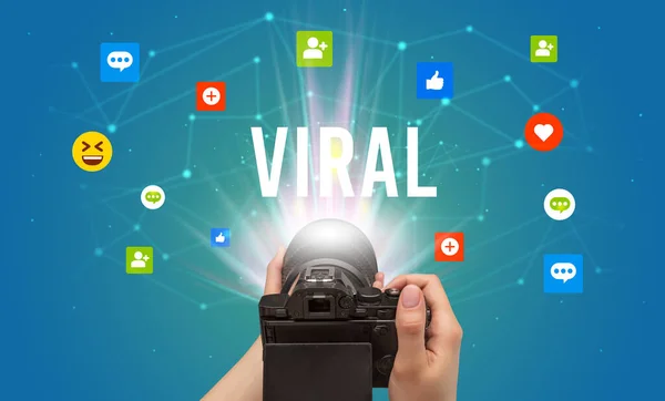Using camera to capture social media content with VIRAL inscription, social media content concept