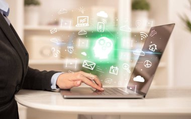 Bilgisayarda çalışan bir iş adamı, içinden ikonların çıktığını düşünen bir adamla iş dünyası konseptini büyütüyor.