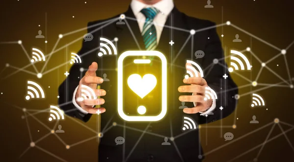 Hand holdig smartphone with heart icon around his hands, Social networking concept