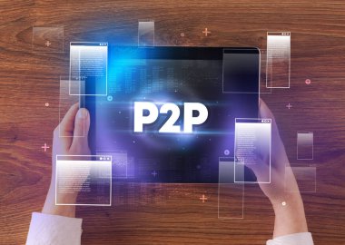 Close-up of a hand holding tablet with P2P abbreviation, modern technology concept clipart