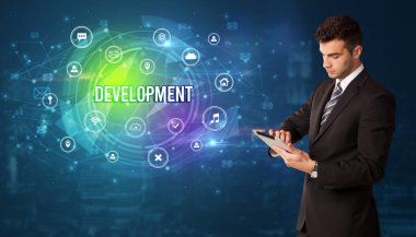 Teknolojiyle ilgili ikonlar ve DEVELOPMENT yazıtları ve modern teknoloji kavramı önünde düşünen iş adamı