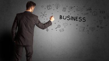 İş adamı, BUSINESS yazıtları ve iş stratejisi konseptiyle yaratıcı bir fikir çizimi yapıyor.