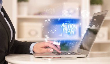 ACTION PLAN yazıtları, modern iş konsepti ile birlikte dizüstü bilgisayarda çalışan bir iş adamının yan görüntüsü