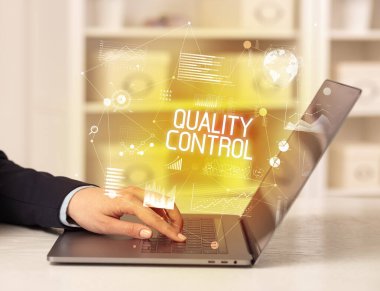 Bilgisayarda çalışan bir iş adamının yan görünüşü KALİTİLİK KONTROL yazıtları, modern iş konsepti