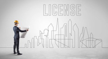 LICENSE Yazı, Mühendislik ve Mimarlık konsepti olan sağlam şapkalı bir işadamı.