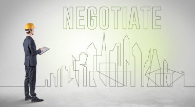 Elinde NEGOTIATE yazıtları, mühendisliği ve mimari konsepti olan sağlam şapkalı bir işadamı.