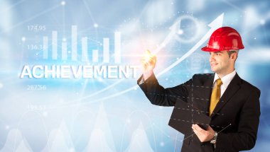 Miğferli genç işadamı ACHIEVEMENT yazıtları, modern iş teknolojisi konsepti