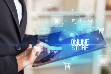 Genç kişi, ONLINE Mağazası yazısıyla çevrimiçi alışveriş uygulaması üzerinden alışveriş yapıyor