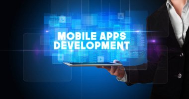Tablet üzerinde çalışan genç iş adamı ve yazıyı gösteriyor: MOBILE APPS DEVELOPMENT