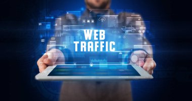 Tablet üzerinde çalışan genç iş adamı dijital işareti gösteriyor: WeB TRAFFIC