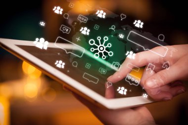 Bağlantı simgeleri içeren tablet kullanan bir elin yakın plan görüntüsü, sosyal medya kavramı