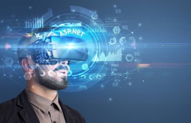 İş adamı ASP.NET yazıtları ve yenilikçi teknoloji konseptiyle Sanal Gerçeklik gözlüklerine bakıyor.