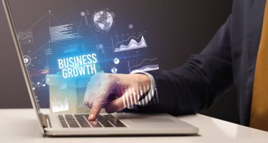 İş adamı bilgisayarında Business Growth yazıtı ve yeni iş konseptiyle çalışıyor.