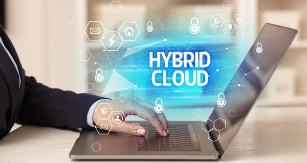 HYBRID CLOUD inscription on laptop, internet security and data protection concept, blockchain and cybersecurity