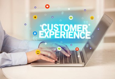 Diz üstü bilgisayarı kullanan serbest çalışan bir kadın CUSTOMER ExperICE yazıtları, sosyal medya kavramı