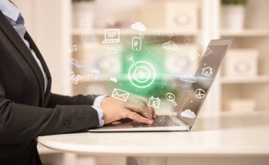 Bilgisayarda çalışan iş adamı, içinden hedef simgeler çıkıyor ve iş dünyası kavramı büyüyor.