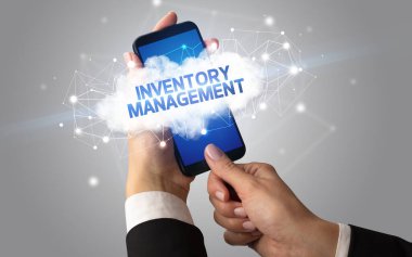 Dişi el akıllı telefona dokunuyor InVENTORY MANAGEMENT yazıtları, bulut iş konsepti