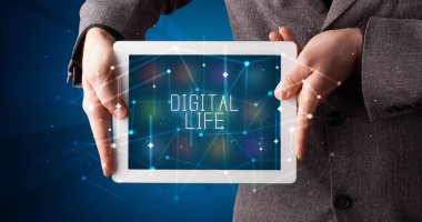 Tablet üzerinde çalışan genç iş adamı dijital işareti gösteriyor: DİGITAL HAYAT