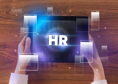 İnsan Kaynakları kısaltmalı el ele tutuşma tableti, modern teknoloji kavramı.