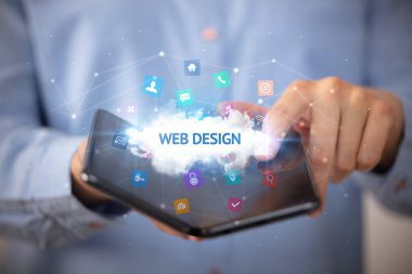WeB DESIGN yazıtlı, teknoloji konseptli katlanabilir bir akıllı telefon tutan bir iş adamı