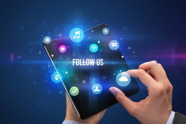 FOLLOW ABD yazıtları ve sosyal medya kavramına sahip katlanabilir bir akıllı telefon tutan iş adamı