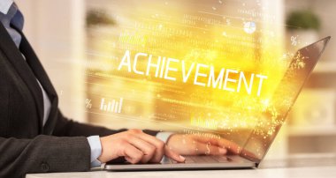 İş adamlarının dizüstü bilgisayarda ACHIEVEMENT yazıtları ve başarılı iş konsepti ile birlikte çalışması