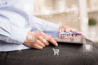 Genç kişi, Kara Cuma yazıtı ile online alışveriş uygulaması üzerinden alışveriş yapıyor