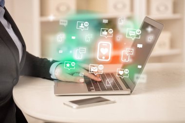 Bilgisayarda kalp simgeli akıllı telefonla sörf yapan genç insan, sosyal medya kavramı