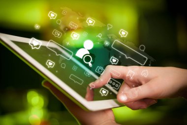 Tablet kullanan bir elin yakın plan görüntüsü, arama yapan insanların simgeleri, sosyal medya kavramı