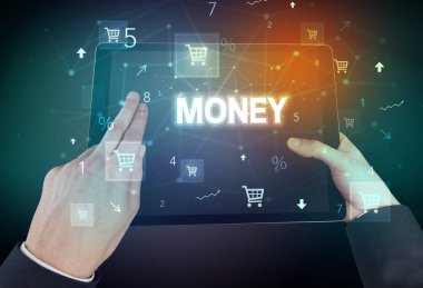 El ele tutuşma tabletinin yakın plan fotoğrafı. Üzerinde para yazılı, online alışveriş konsepti var.