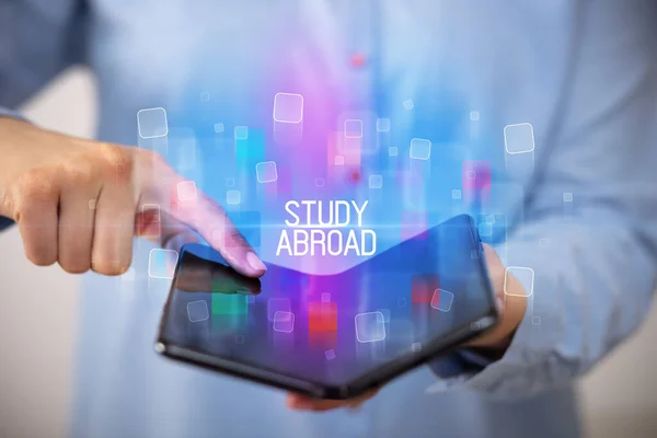 Ung Mand Med Sammenklappelig Smartphone Med Study Abroad Indskrift Uddannelseskoncept - Stock-foto