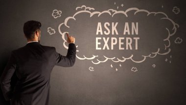 İş adamı, içinde Ask An Expert yazıtı olan bir bulut çiziyor, modern iş konsepti.