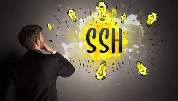 businessman drawing colorful light bulb with SSH abbreviation, new technology idea concept