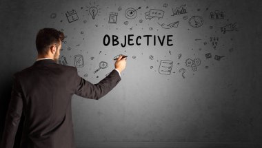 İş adamı, OBJECTIVE yazıtları ve iş stratejisi konseptiyle yaratıcı bir fikir çizimi yapıyor.