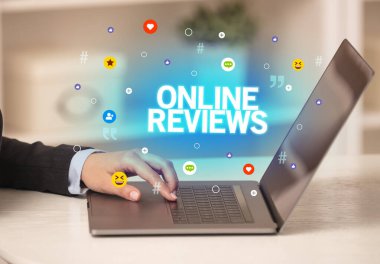 ONLINE REVIEWS yazıtlı, Sosyal medya konseptli dizüstü bilgisayar kullanan serbest çalışan kadın
