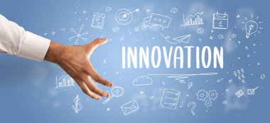 Kesilmiş ellerin yakın çekimi INNOVATION yazıtlarına işaret ediyor, modern iş çözümleri kavramı