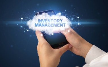 Dişi el akıllı telefona dokunuyor InVENTORY MANAGEMENT yazıtları, bulut iş konsepti