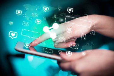 Ağdan çıkan simgelerle birlikte tablet kullanan bir elin yakın plan görüntüsü, sosyal medya kavramı