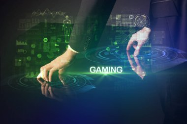 İşadamı büyük ekrana GAMING yazısıyla dokunuyor, modern teknoloji konsepti.