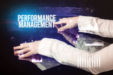 İş adamı Performans Yönetimi yazıtları ve siber iş konseptiyle büyük ekrana dokunuyor.