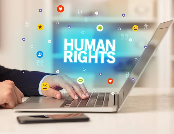 stock image Freelance woman using laptop with HUMAN RIGHTS inscription, Social media concept