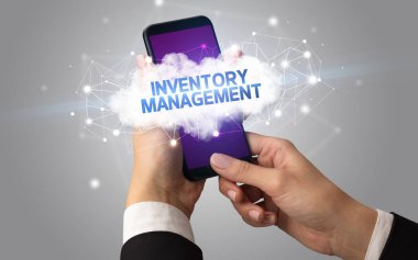 Dişi el akıllı telefona dokunuyor InVENTORY MANAGEMENT yazıtları, bulut iş konsepti