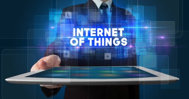 Tablet üzerinde çalışan genç iş adamı ve yazıtı gösteriyor: Nesnelerin İnterneti