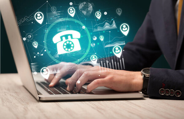 Бизнес-рука, работающая на ноутбуке с телефоном, выходящим с экрана, успешная бизнес-концепция