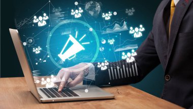 Bilgisayarda çalışan iş adamı ekrandan megafon simgeleri çıkıyor, başarılı iş konsepti