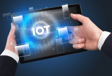 IOT kısaltması ile el ele tutuşma tableti, modern teknoloji konsepti