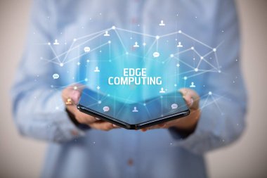 İş adamı elinde EDGE ile katlanabilir bir akıllı telefon tutuyor. Yazı, yeni teknoloji konsepti.